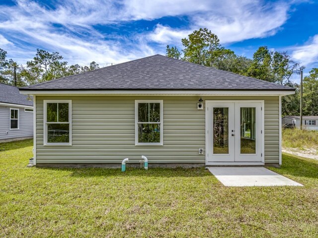 back of property featuring a yard and french doors