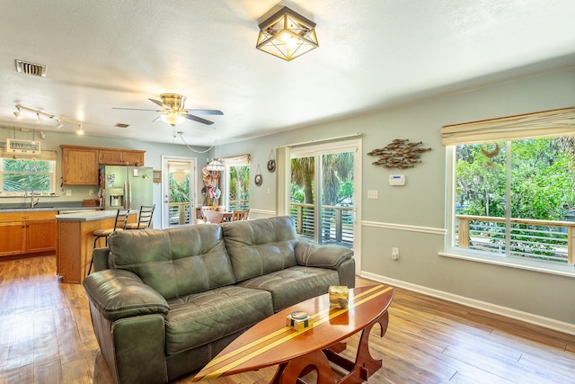 627 Mariner Cir, Alligator Point, FL 32346 - living room featuring light wood finished floors, a ceiling fan, and baseboards