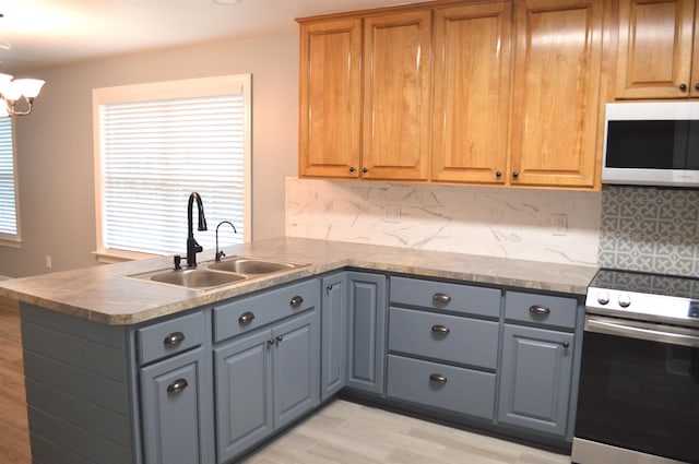 kitchen featuring electric range, decorative backsplash, gray cabinets, a notable chandelier, and kitchen peninsula