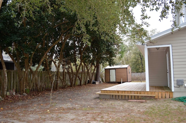 view of yard featuring a wooden deck and a shed