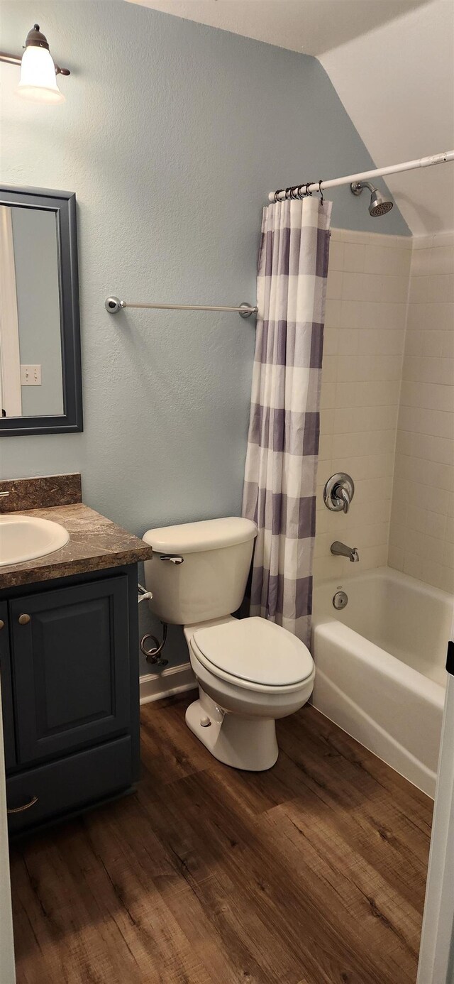 full bathroom featuring shower / bath combo, vanity, wood-type flooring, toilet, and lofted ceiling