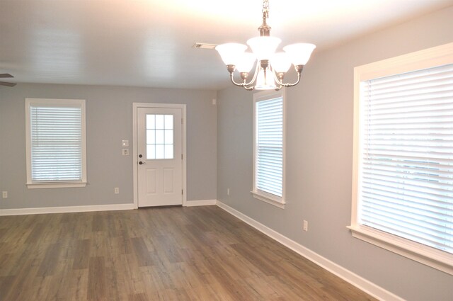 foyer with ceiling fan with notable chandelier and dark hardwood / wood-style flooring