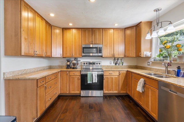 kitchen featuring hanging light fixtures, appliances with stainless steel finishes, dark wood-style flooring, and a sink