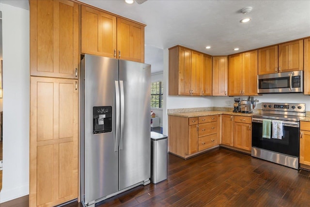 kitchen with brown cabinetry, stainless steel appliances, dark wood-style flooring, and recessed lighting