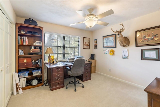 office space with light carpet, ceiling fan, and baseboards