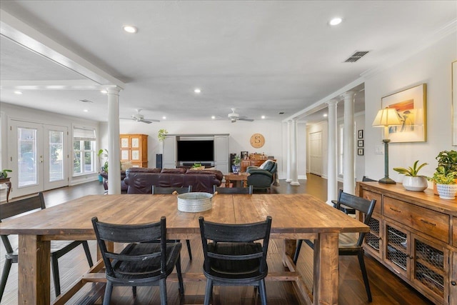 dining room featuring visible vents, dark wood finished floors, ceiling fan, french doors, and ornate columns