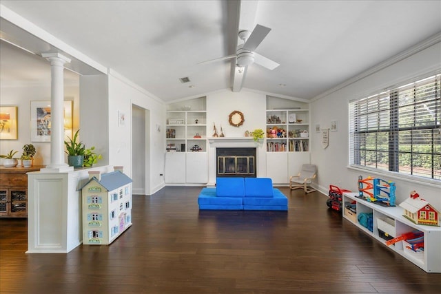 playroom with decorative columns, built in features, dark wood-style flooring, and a glass covered fireplace