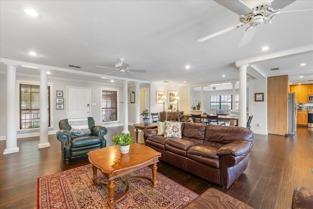 living area with a ceiling fan, dark wood-style floors, crown molding, ornate columns, and recessed lighting