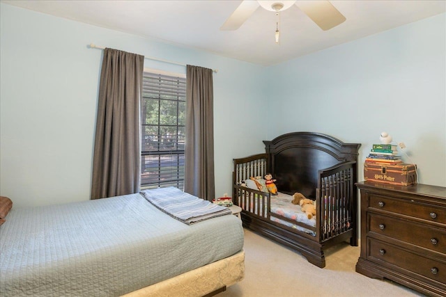 bedroom with a ceiling fan and light colored carpet