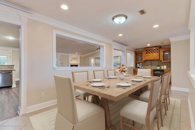 dining space featuring ceiling fan, ornamental molding, and light tile patterned floors