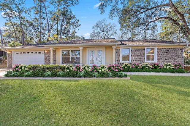 single story home featuring french doors, a front yard, and a garage