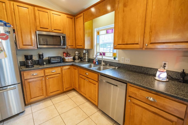 3204 Gallant Fox Trl, Tallahassee, FL 32309 - kitchen featuring stainless steel appliances, a sink, brown cabinetry, vaulted ceiling, and light tile patterned floors