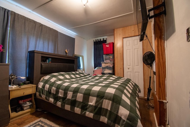 bedroom featuring wood-type flooring, a closet, and wood walls