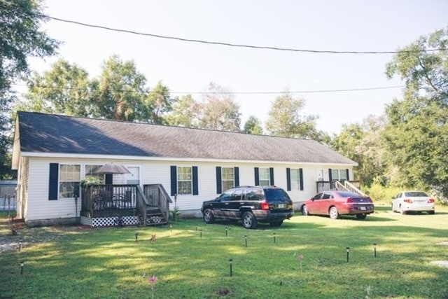 single story home with a deck and a front yard