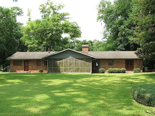 3705 Foxford Cir, Tallahassee, FL 32309 - ranch-style home with a sunroom, a front lawn, a chimney, brick siding, and central AC