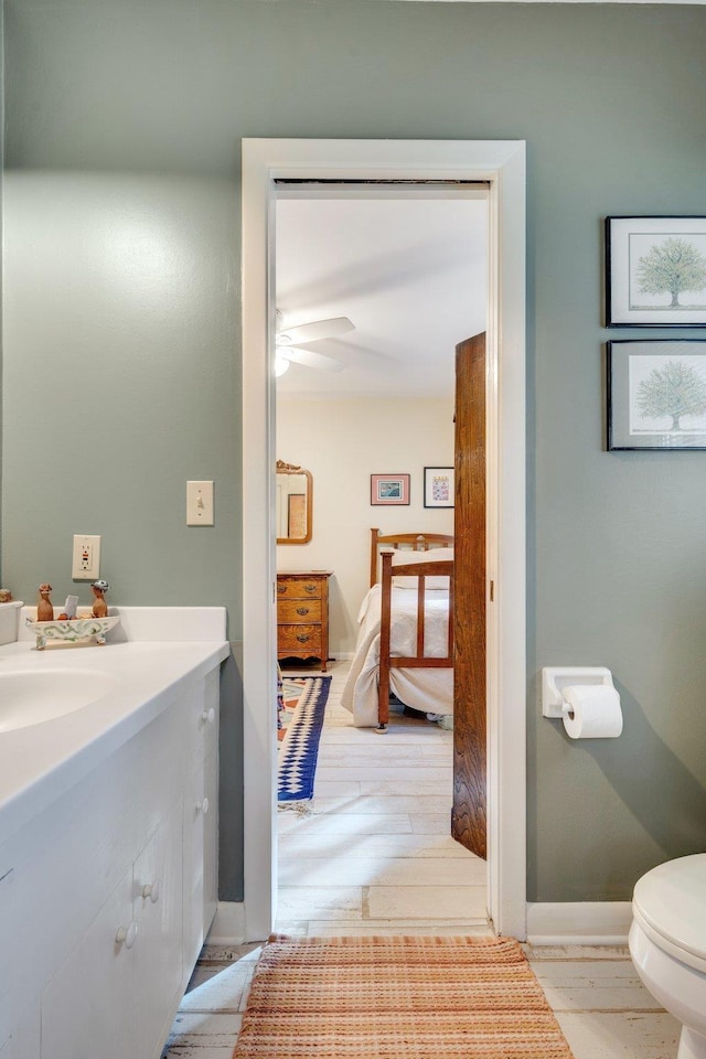 bathroom featuring vanity, ceiling fan, hardwood / wood-style flooring, and toilet