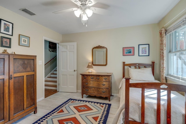 bedroom with ceiling fan, multiple windows, and light wood-type flooring