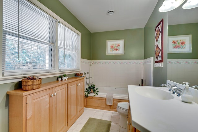 bathroom featuring tile patterned flooring, tile walls, a bathtub, vanity, and toilet