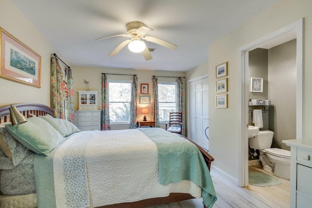 bedroom featuring ensuite bathroom, ceiling fan, light wood-type flooring, and a closet