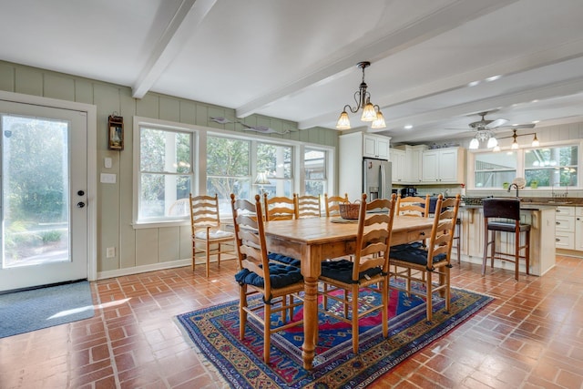 dining room featuring beamed ceiling and sink