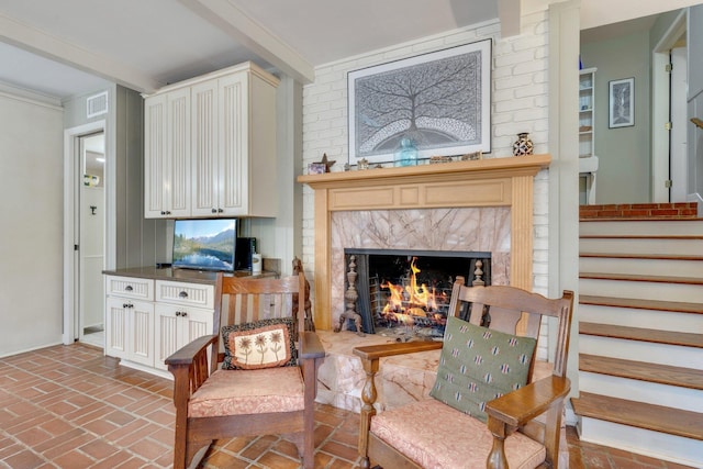 living area with beamed ceiling and a premium fireplace