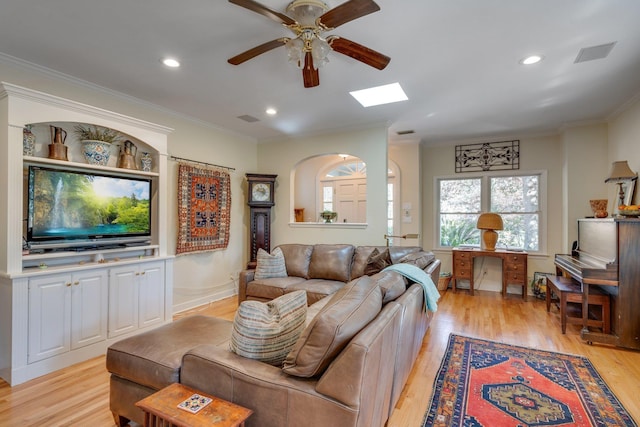 living room featuring ornamental molding, light hardwood / wood-style floors, and ceiling fan