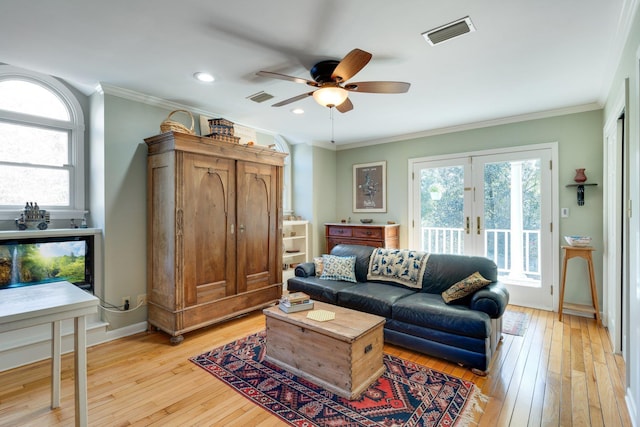 living room featuring crown molding, french doors, ceiling fan, and light wood-type flooring