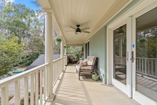 balcony with french doors, ceiling fan, and covered porch