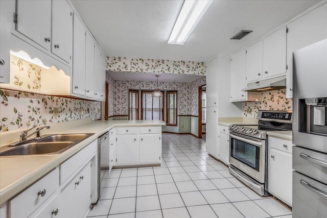 kitchen featuring wallpapered walls, appliances with stainless steel finishes, light countertops, under cabinet range hood, and a sink