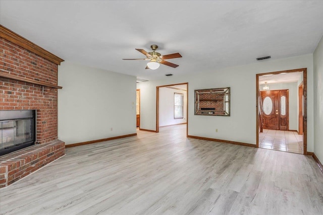 unfurnished living room featuring a healthy amount of sunlight, light wood-style floors, and a fireplace