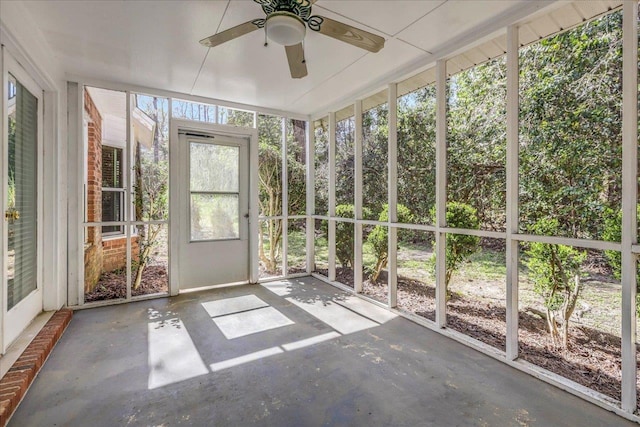 unfurnished sunroom with ceiling fan