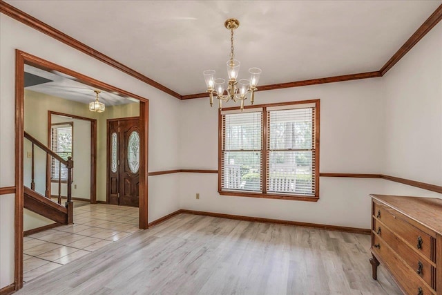 interior space featuring crown molding, baseboards, light wood-style flooring, and an inviting chandelier