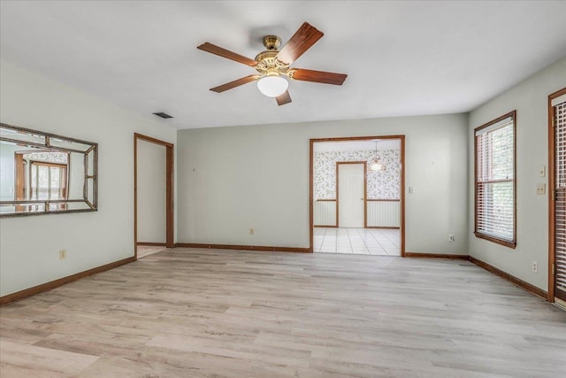 spare room with visible vents, baseboards, and wood finished floors