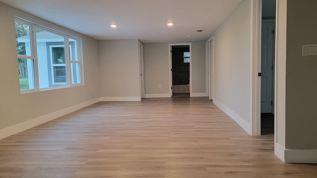 unfurnished room with a healthy amount of sunlight and light hardwood / wood-style floors