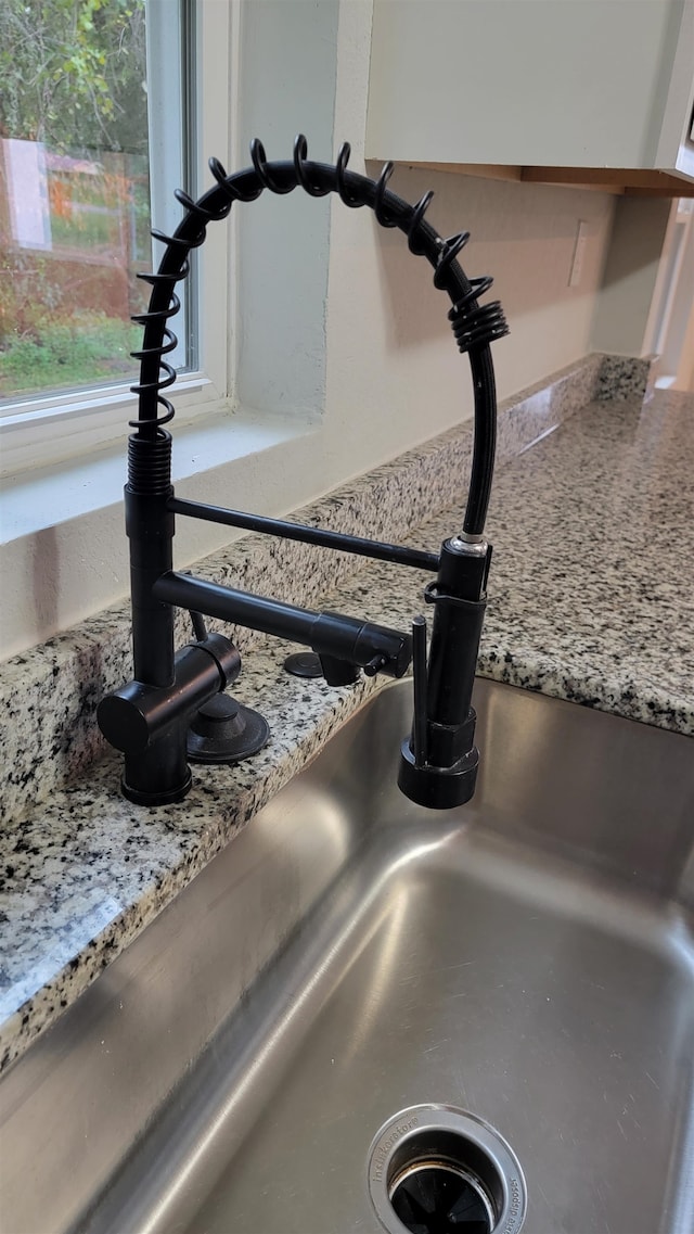 room details with light stone countertops and sink