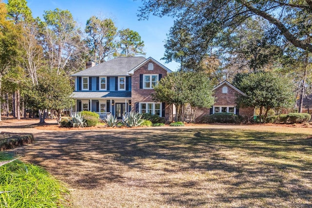 view of front facade featuring covered porch and a front lawn