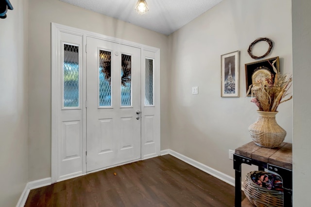 foyer featuring dark wood-type flooring and a textured ceiling