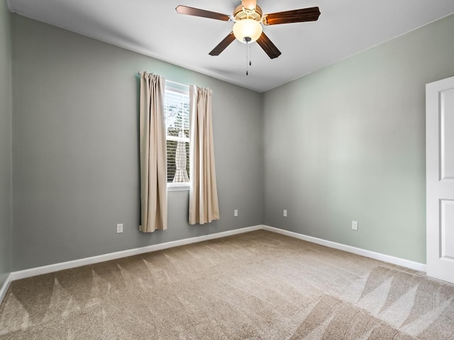 spare room featuring ceiling fan, carpet floors, and baseboards