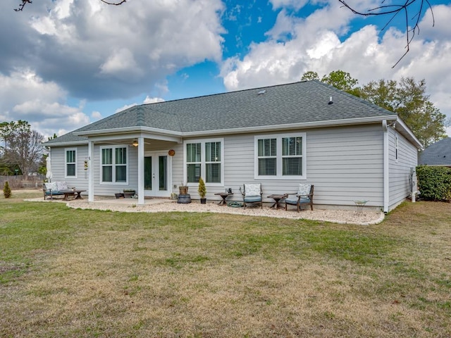 rear view of house with a lawn, a shingled roof, french doors, and a patio area