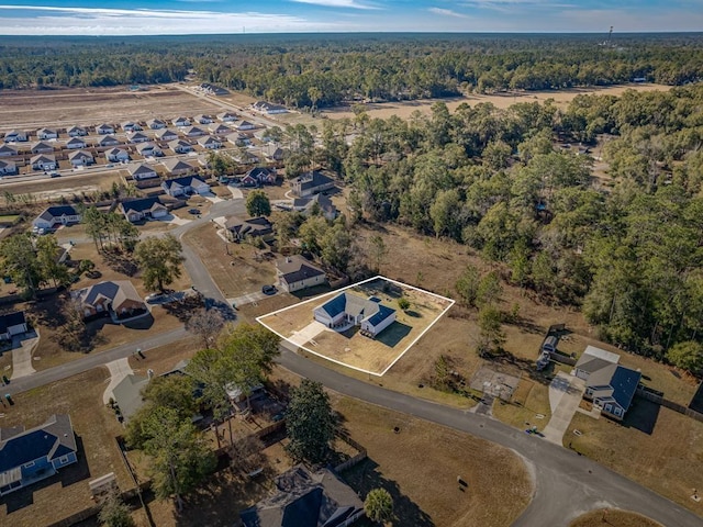 drone / aerial view with a residential view and a view of trees