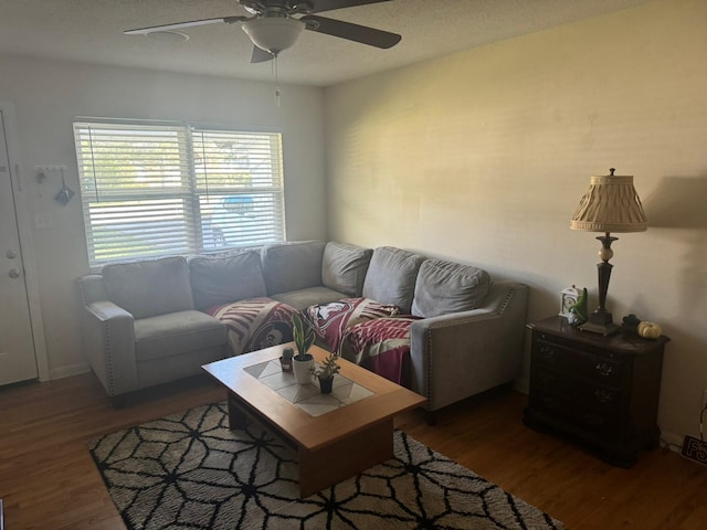 living room with dark wood-type flooring and ceiling fan