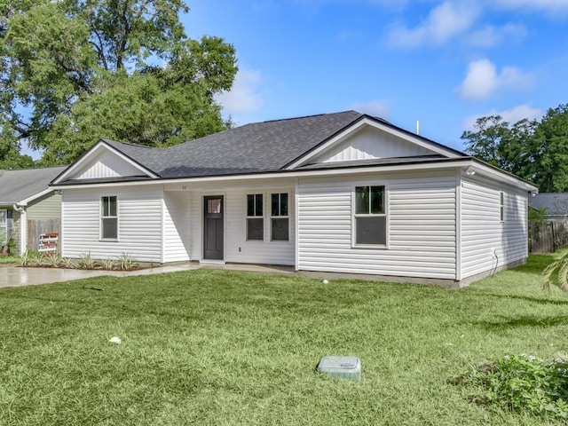 view of front of home featuring a shingled roof and a front yard