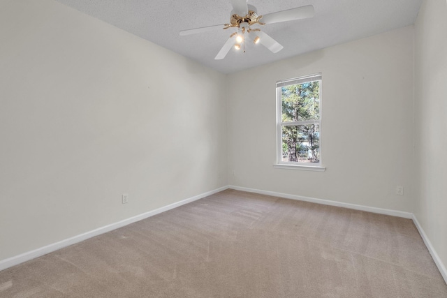 spare room with ceiling fan, light colored carpet, and a textured ceiling