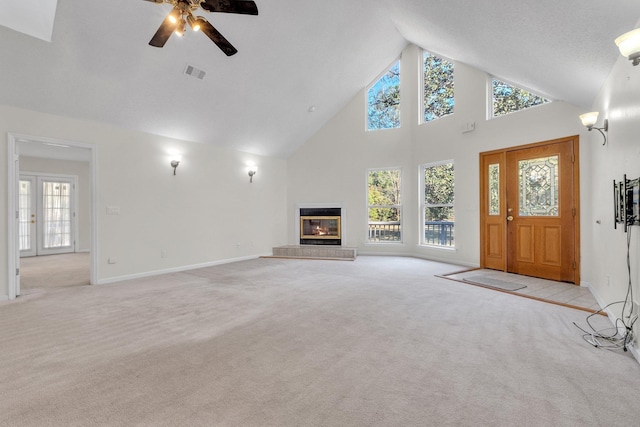 unfurnished living room with high vaulted ceiling, light colored carpet, and ceiling fan