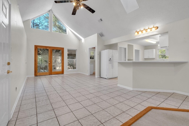 unfurnished living room with ceiling fan, light tile patterned flooring, and high vaulted ceiling