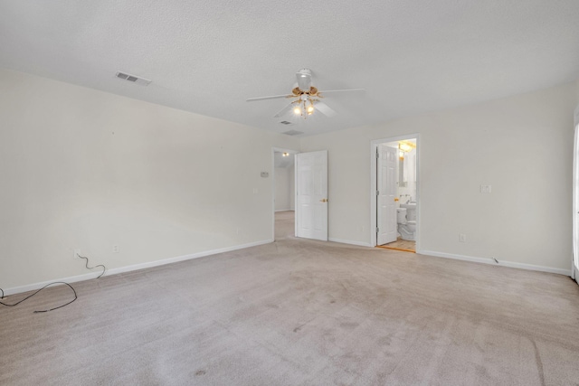 carpeted empty room with ceiling fan and a textured ceiling