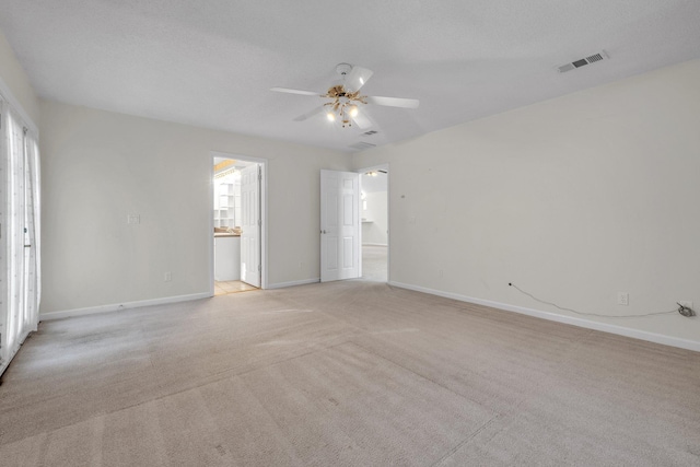 spare room with ceiling fan and light carpet