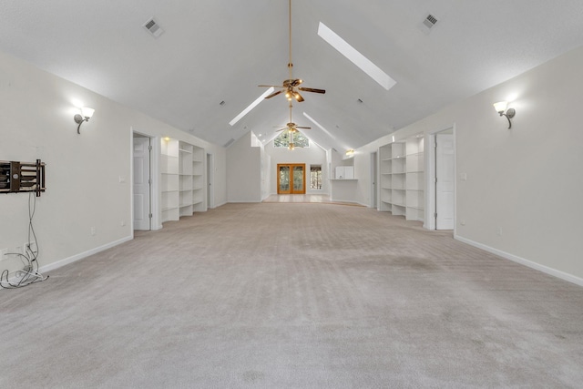 unfurnished living room with ceiling fan, built in shelves, light carpet, and lofted ceiling with skylight