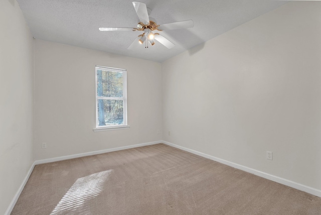 unfurnished room with a textured ceiling, ceiling fan, and light colored carpet