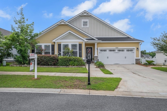 3260 Coneflower Dr, Tallahassee, FL 32311 - craftsman inspired home featuring board and batten siding, an attached garage, driveway, stone siding, and a front yard